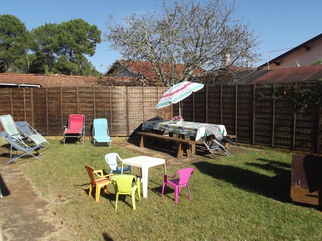 - un groupe de chaises et une table avec un parasol dans l'établissement PROCHE DE LA NATURE, à Mimizan
