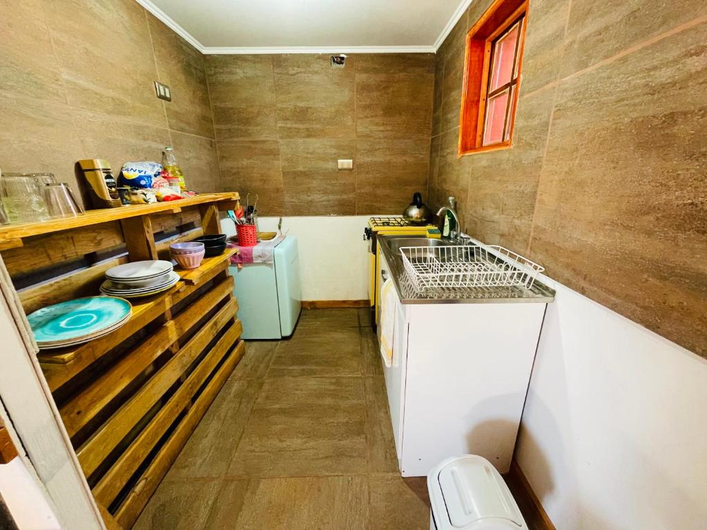 a small kitchen with a sink and a dishwasher at Cabañas Turi Lackar in San Pedro de Atacama