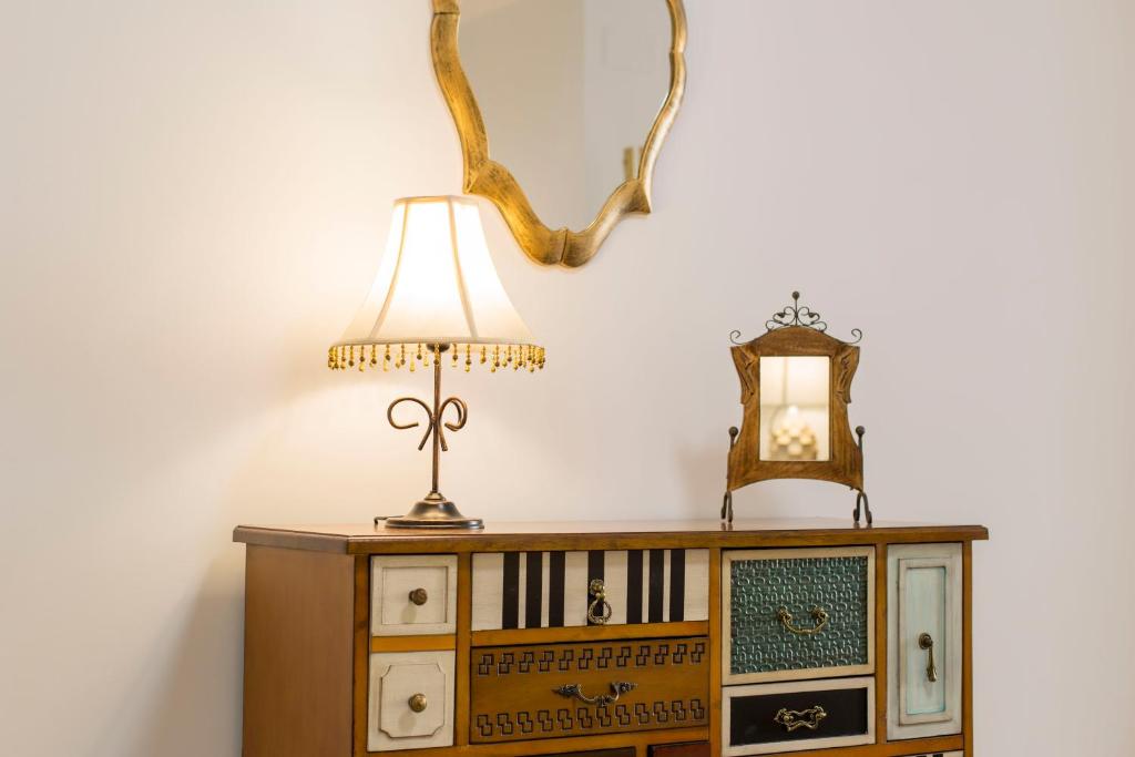 een lamp op een dressoir met een spiegel bij Precioso Loft El Arcángel II junto a la Ribera in Córdoba