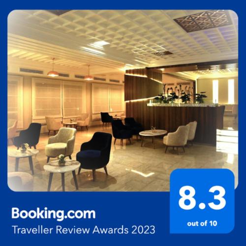 a lobby with chairs and tables and a bar at Hotel Continental in Kairouan