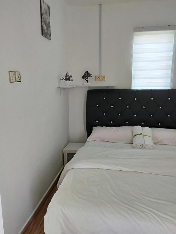 een bed met een zwart hoofdeinde in een slaapkamer bij Inap Idaman 7 5 Pax 2 Queen Plus 1 Sofa Bed in Kota Bharu