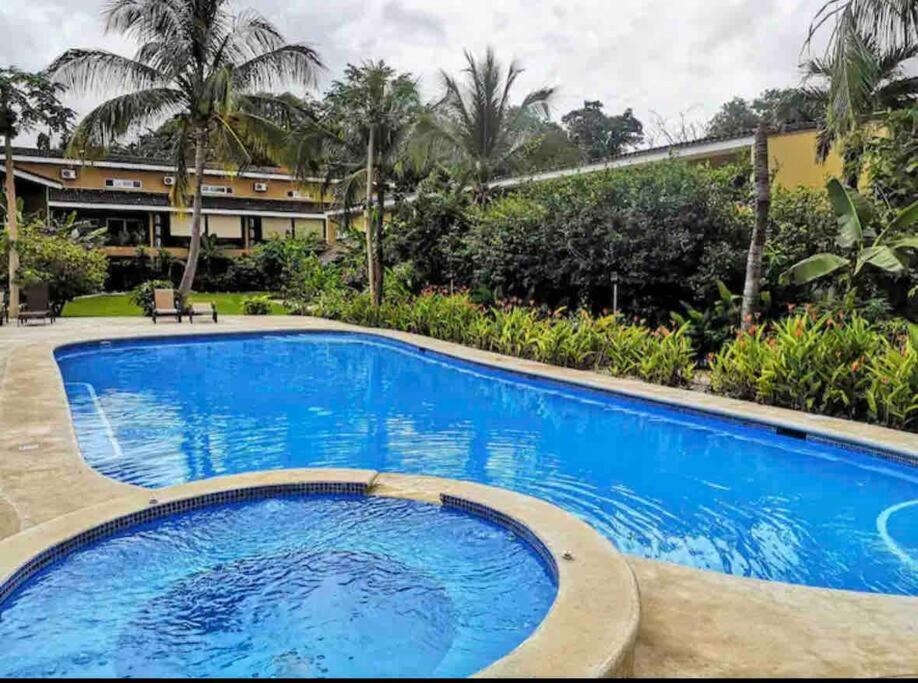 a large blue swimming pool in front of a building at Cabo Velas 19 Jungle Paradise in Santa Cruz