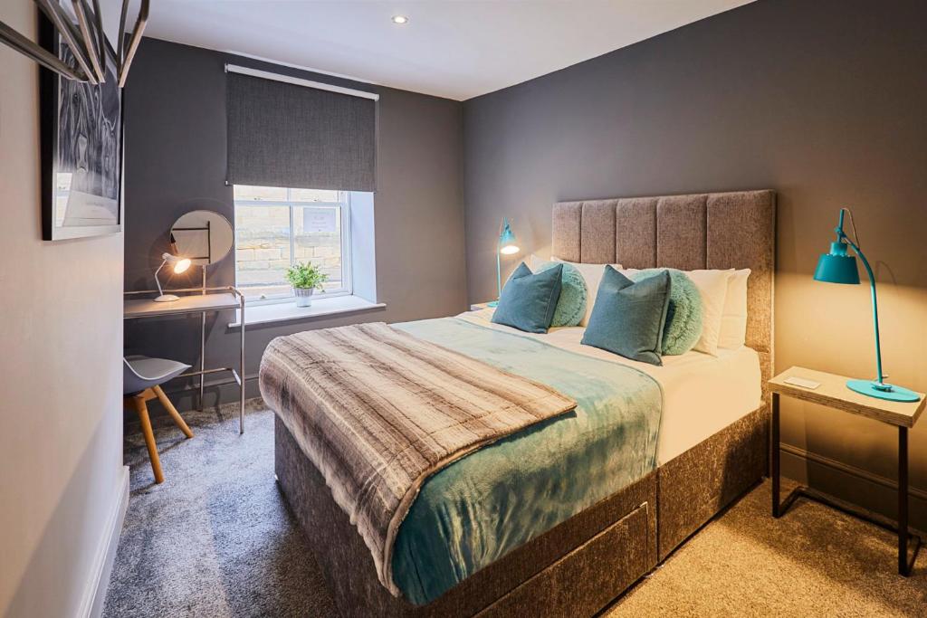 Schlafzimmer mit einem Bett, einem Schreibtisch und einem Fenster in der Unterkunft Host & Stay - Narrowgate Apartments in Alnwick