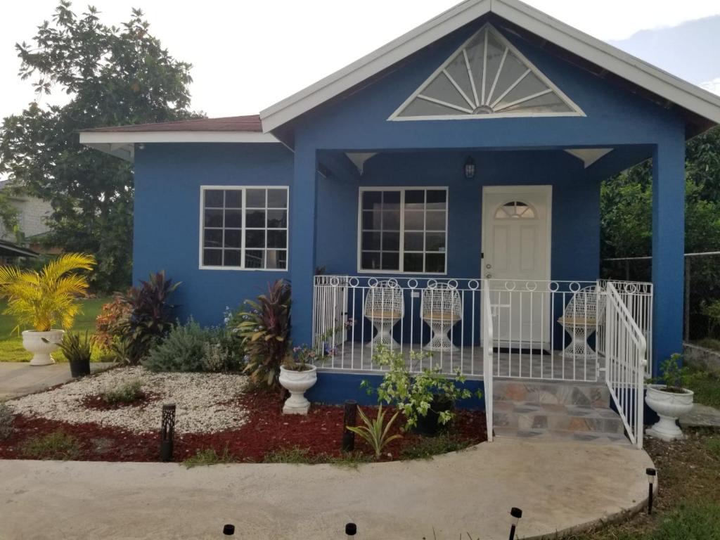ein blaues Haus mit weißem Tor in der Unterkunft Something Blue in Savanna-la-Mar