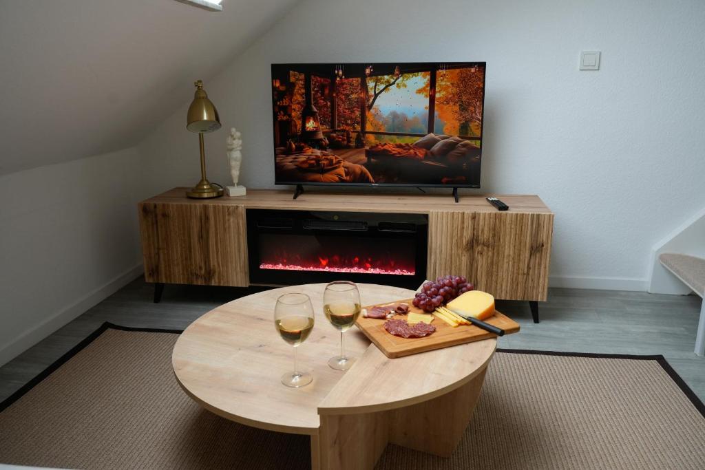 uma sala de estar com uma mesa com dois copos de vinho em Luxuriöses Messe Apartment an der Leineinsel in Hannover, direkt am Wasser in ruhiger Laage em Hanôver