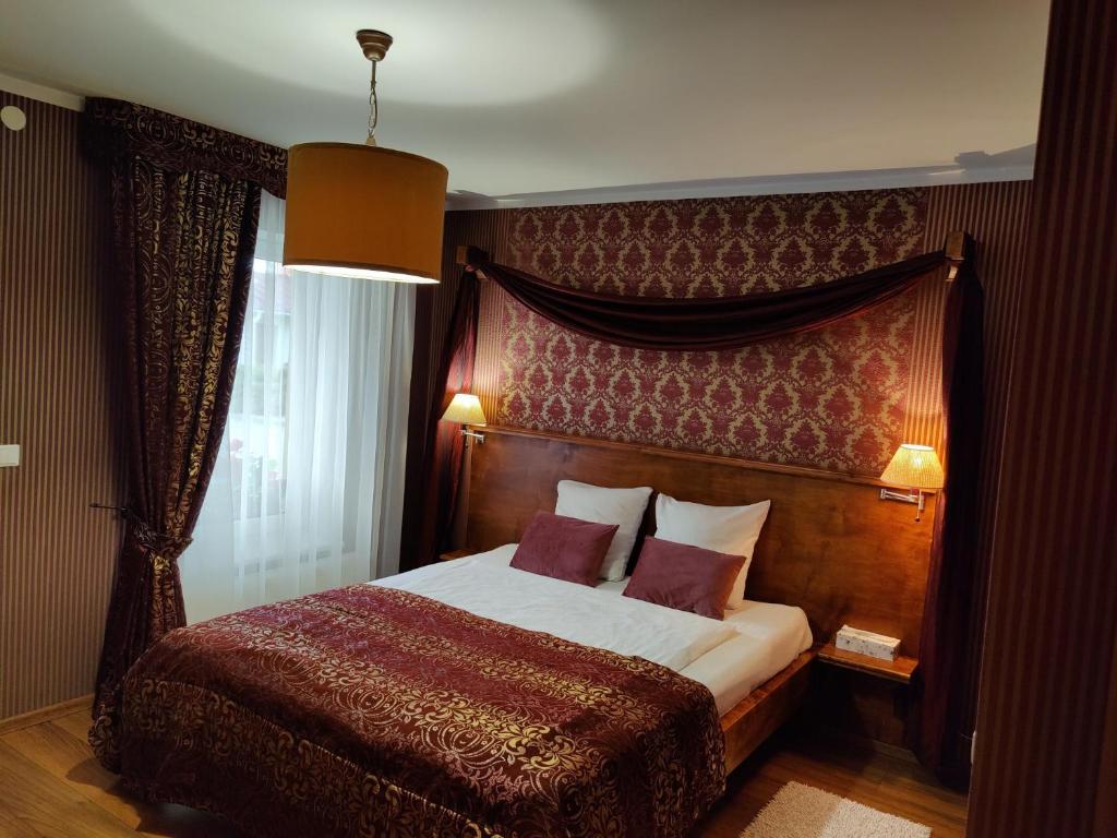 a bedroom with a large bed with a wooden headboard at Motelis SMAKŲ SMAKAS in Šiauliai