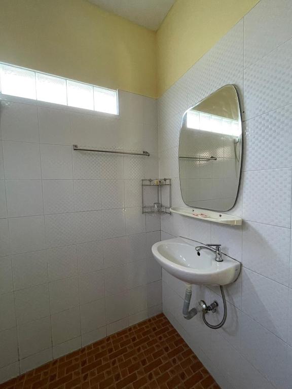 ein weißes Badezimmer mit Waschbecken und Spiegel in der Unterkunft Bangtao Hello House in Strand Bang Tao