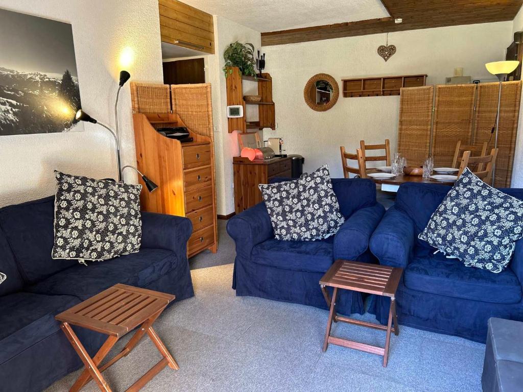 un salon avec un canapé bleu et une table dans l'établissement Appartement 3* aux Gets, proche des pistes, balcon et terrasse, offre tout confort ! - FR-1-623-250, aux Gets