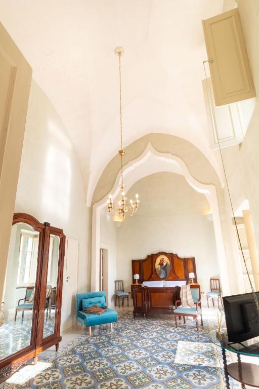 a room with a bed and a table and chairs at Palazzo Zacà in Gallipoli