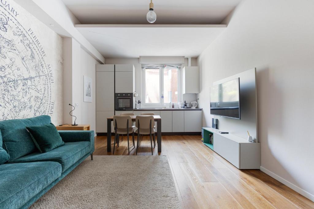 een woonkamer met een groene bank en een keuken bij GuestHost - Bullona Bright & Design Apt - M5 Gerusalemme in Milaan