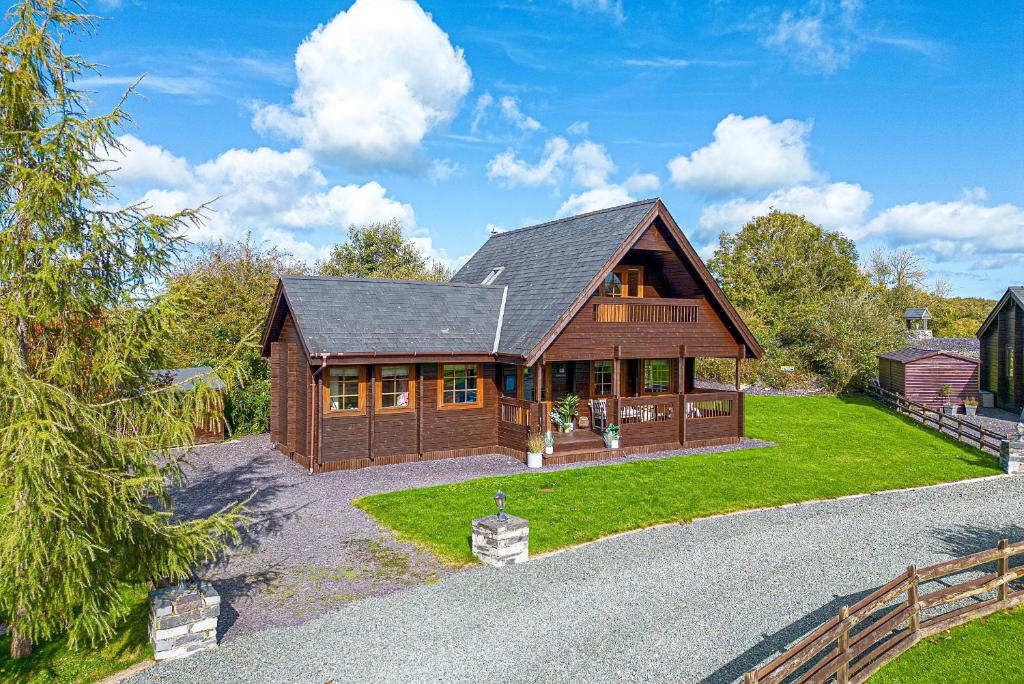 a large wooden house with a large yard at Scandi Cabin in Heart of Anglesey with Parking in Llanfairpwllgwyngyll