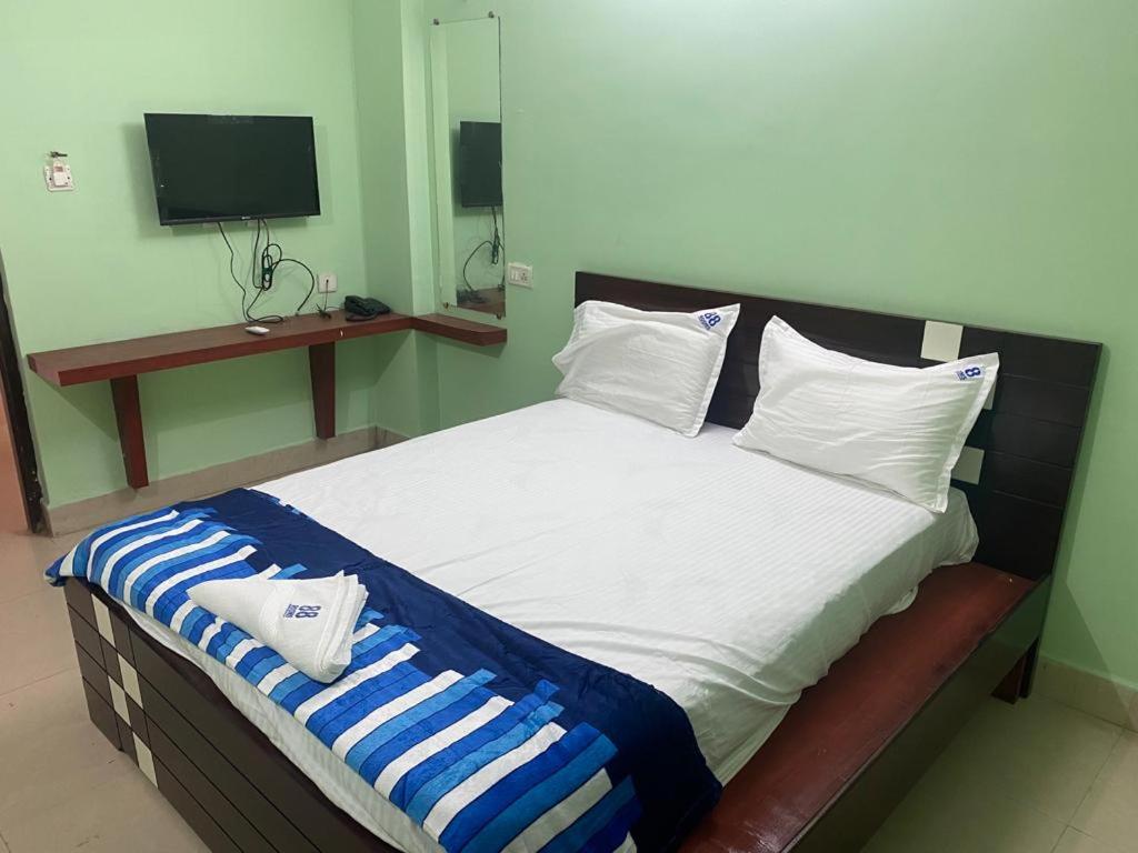 a bedroom with a large bed with blue and white pillows at ARUDRA BUDGET suites in Ongole