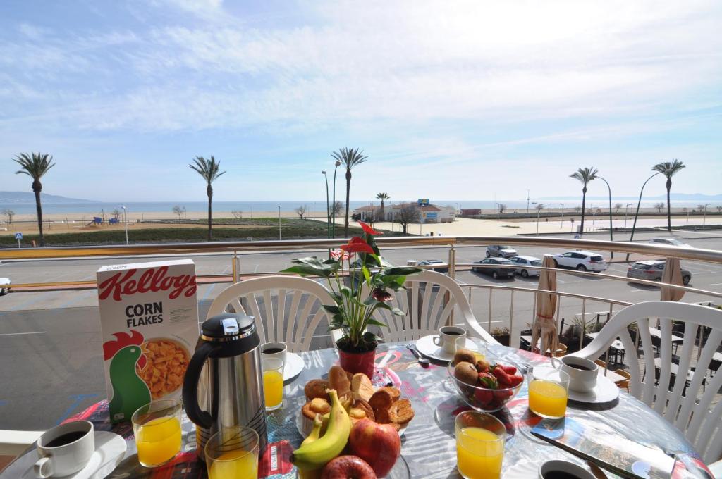un tavolo con prodotti per la colazione e una vista sulla spiaggia di RNET - BCel Empuriabrava a Empuriabrava