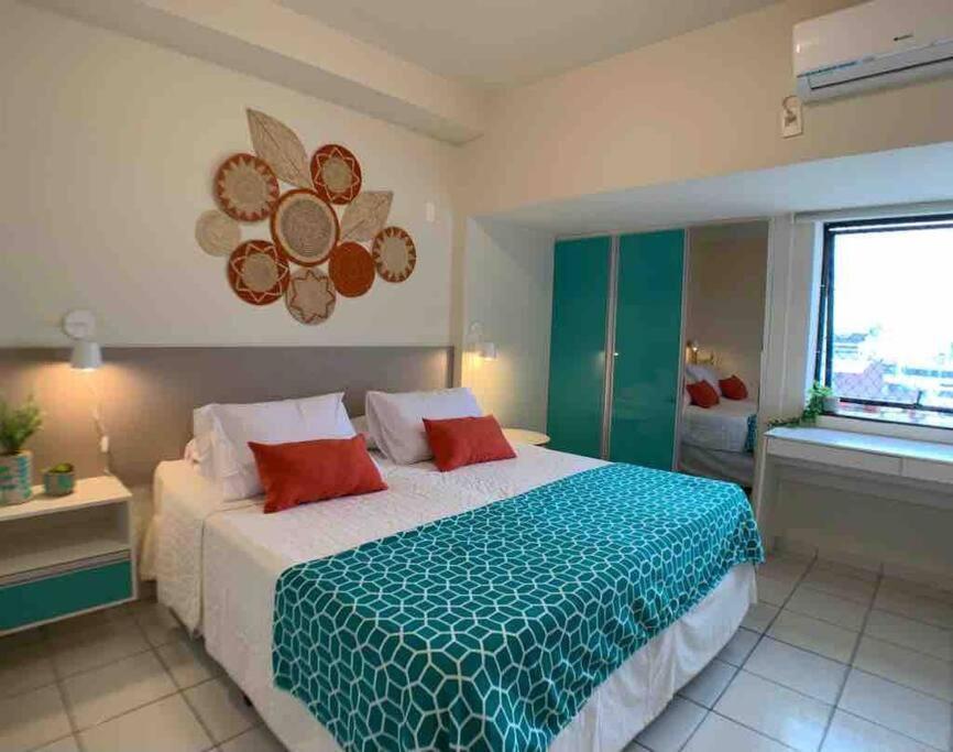 a bedroom with a large bed and a window at Mais espaço com estilo e vista para o mar in João Pessoa