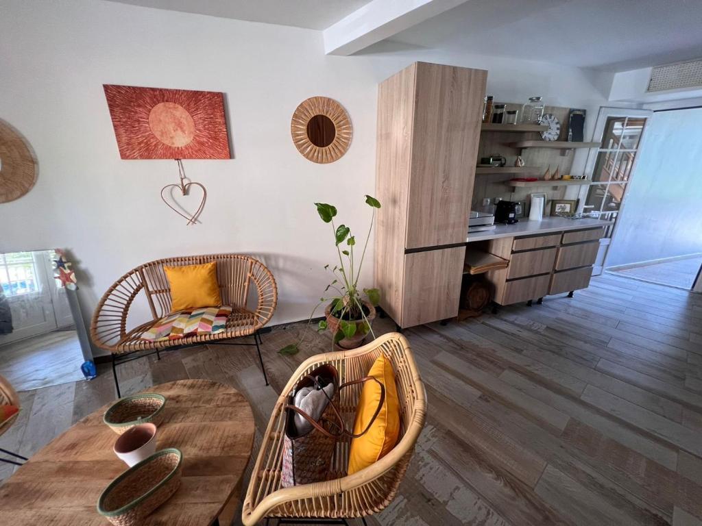 uma sala de estar com mesa e cadeiras e uma cozinha em Bekeke em Capesterre