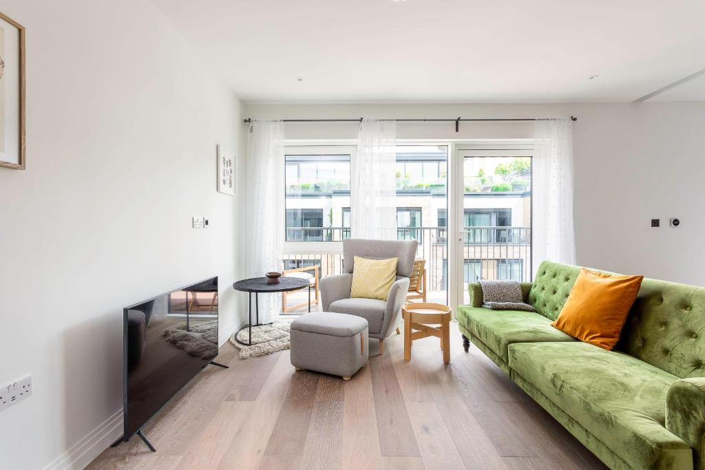 ロンドンにあるModern Chelsea Apartmentのリビングルーム(緑のソファ、椅子付)
