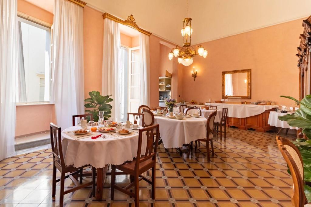 a dining room with tables with white tablecloths at Palazzo Zacà in Gallipoli