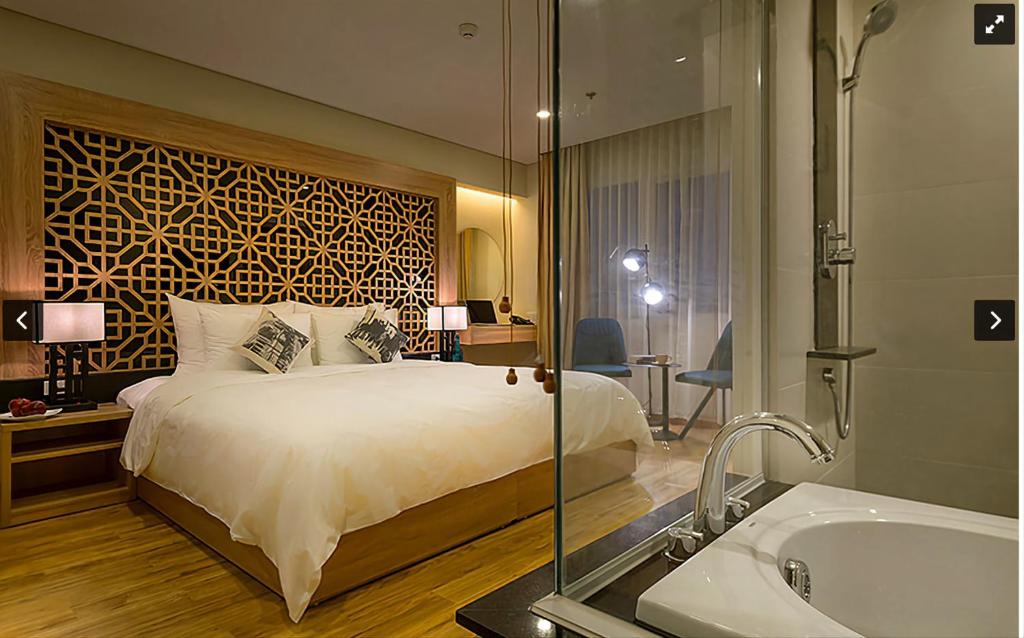 a hotel room with a bed and a bath tub at Gemini Saigon LUXURY in Ho Chi Minh City