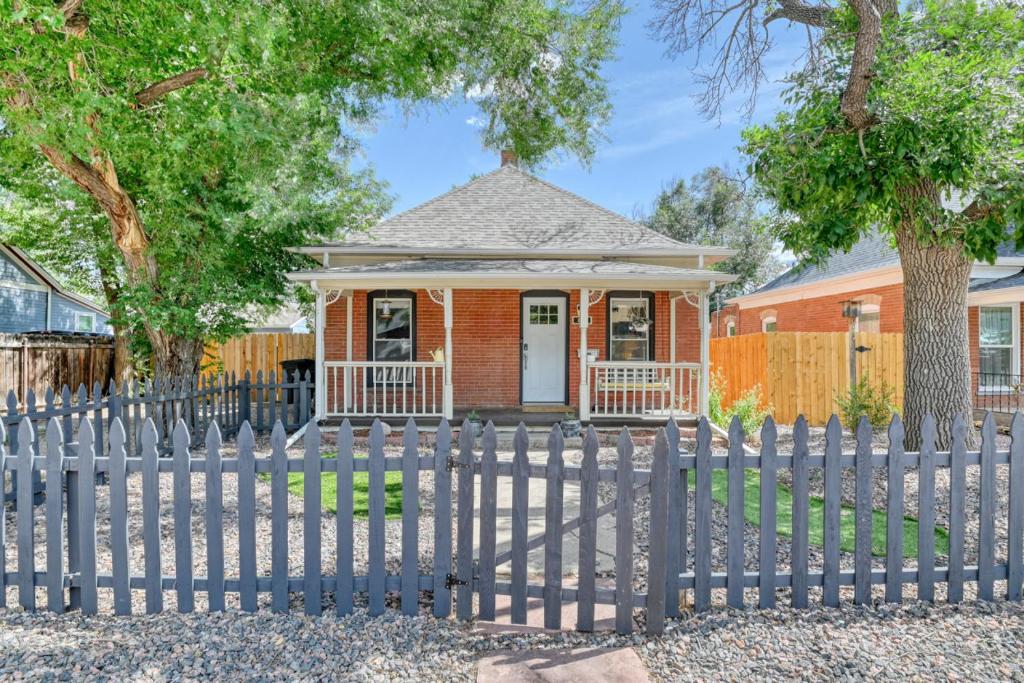 a house with a fence in front of it at Colorado Columbine Cottage in Colorado Springs