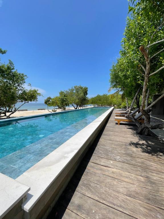 a swimming pool next to a wooden boardwalk at SABAI Beach in Barú