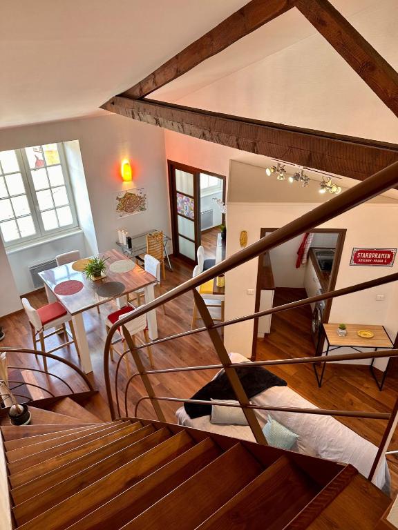 Habitación con escalera y sala de estar con mesa. en Petit nid cosy au cœur du Puy 1 à 5 personnes en Le Puy-en-Velay