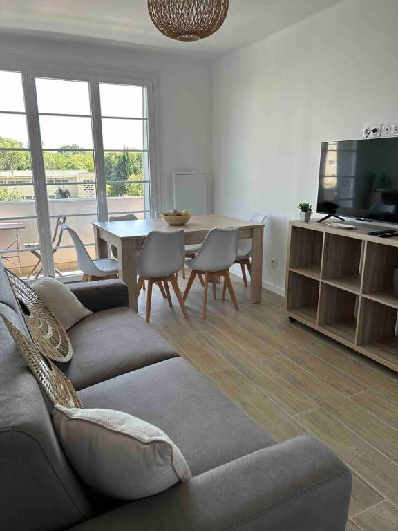 ein Wohnzimmer mit einem Sofa und einem Tisch mit Stühlen in der Unterkunft Le Tendance Patte d'Oie - Lumineux T3 - 4 à 6 Pers in Toulouse