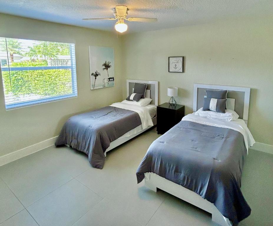 a bedroom with two beds and a window at Casa Flamenco in West Palm Beach