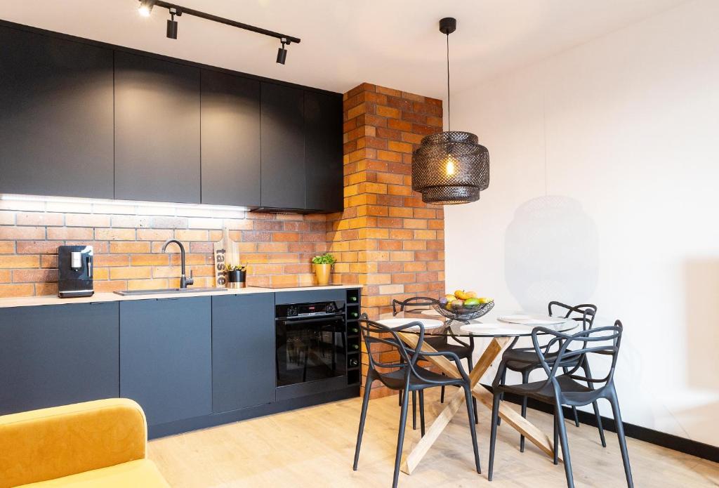 a kitchen with blue cabinets and a table with chairs at KOBIELA APARTMENTS Dębowe Tarasy in Katowice