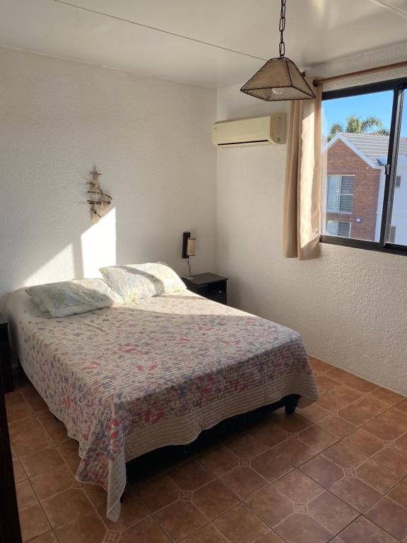 a bedroom with a bed and a window at Medanos del Portal in Piriápolis