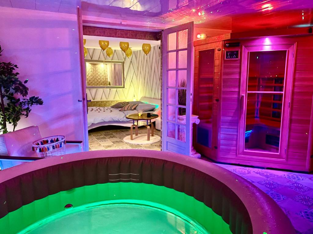 Espace détente jacuzzi sauna في Gagny: حمام سباحة في منزل به أضواء أرجوانية وأخضر