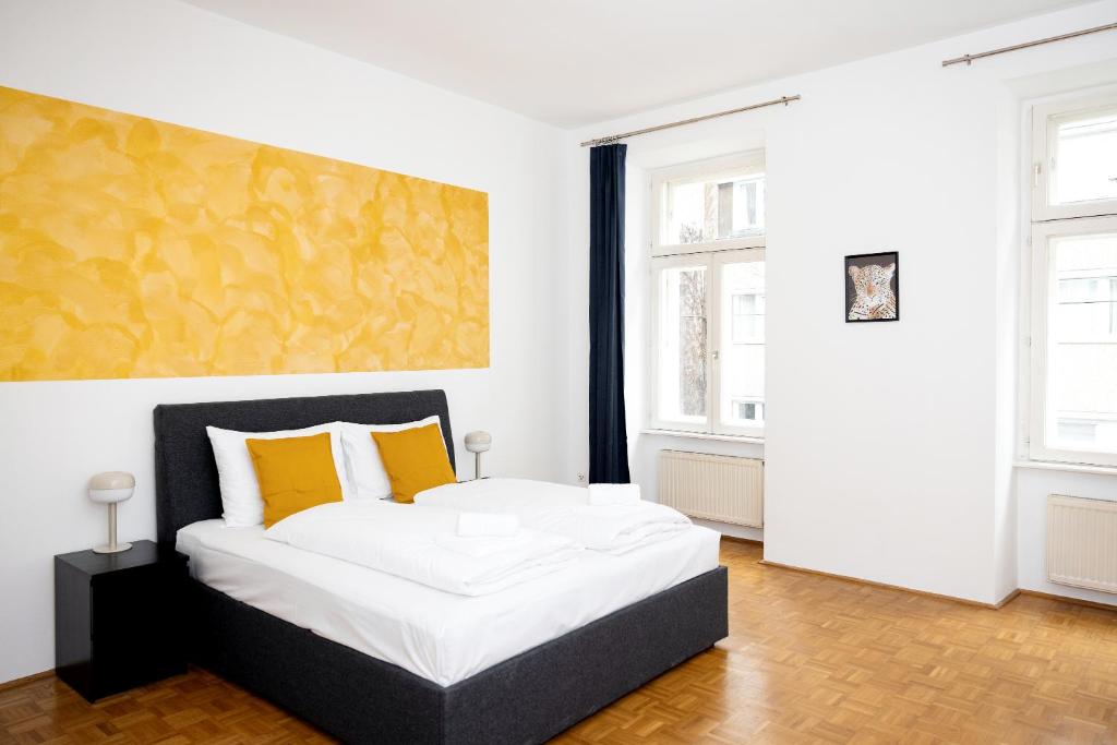 um quarto com uma cama grande e almofadas amarelas em Premium 80 m2 Apartment - 5 min to Center - Free Parking em Viena