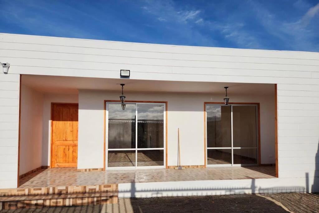 a white building with a door and windows at Casa 10 personas cerca de Bahia Inglesa in Caldera