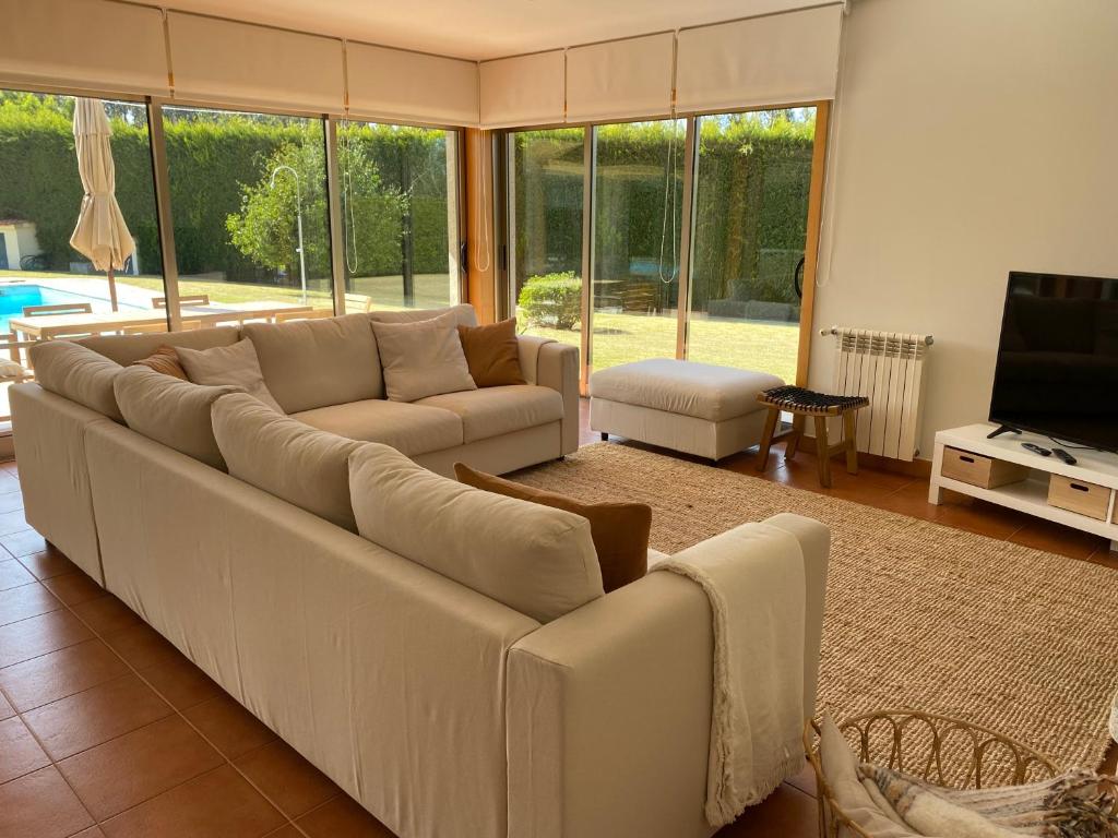 sala de estar con sofá grande y TV en Casa do Lago, Privacidade e Beleza Natural, en Esposende