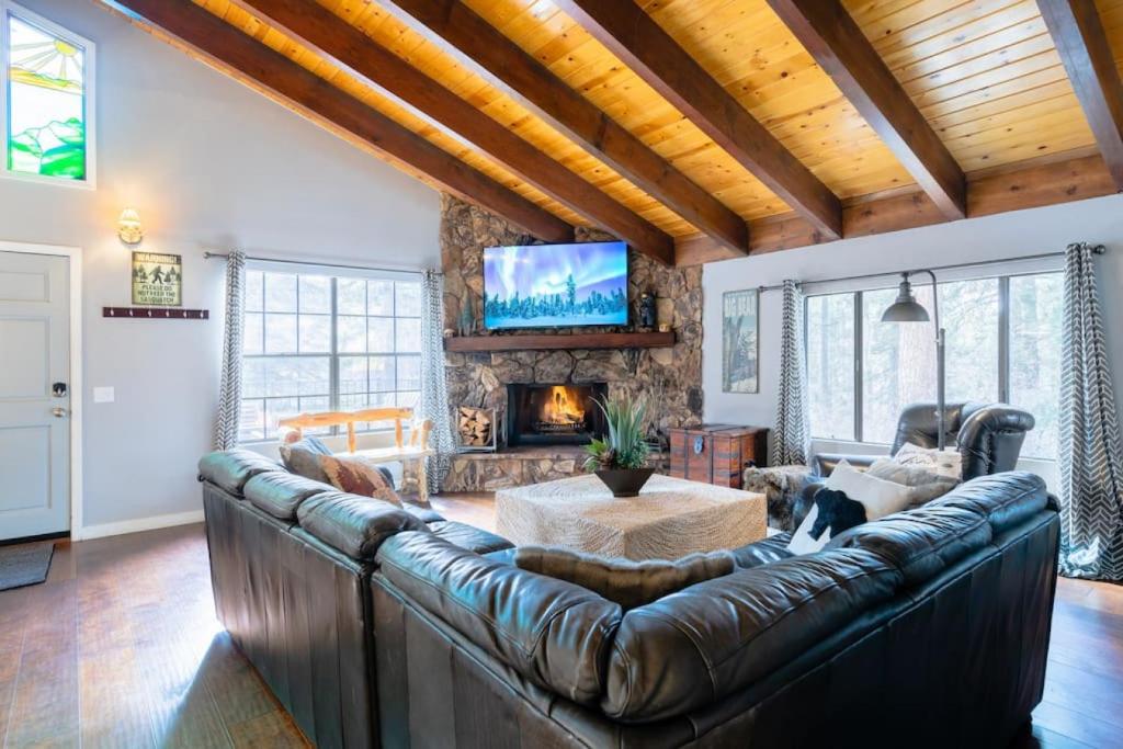 a living room with a leather couch and a fireplace at Winter Getaway Spa Fire-table Close to slopes in Big Bear Lake