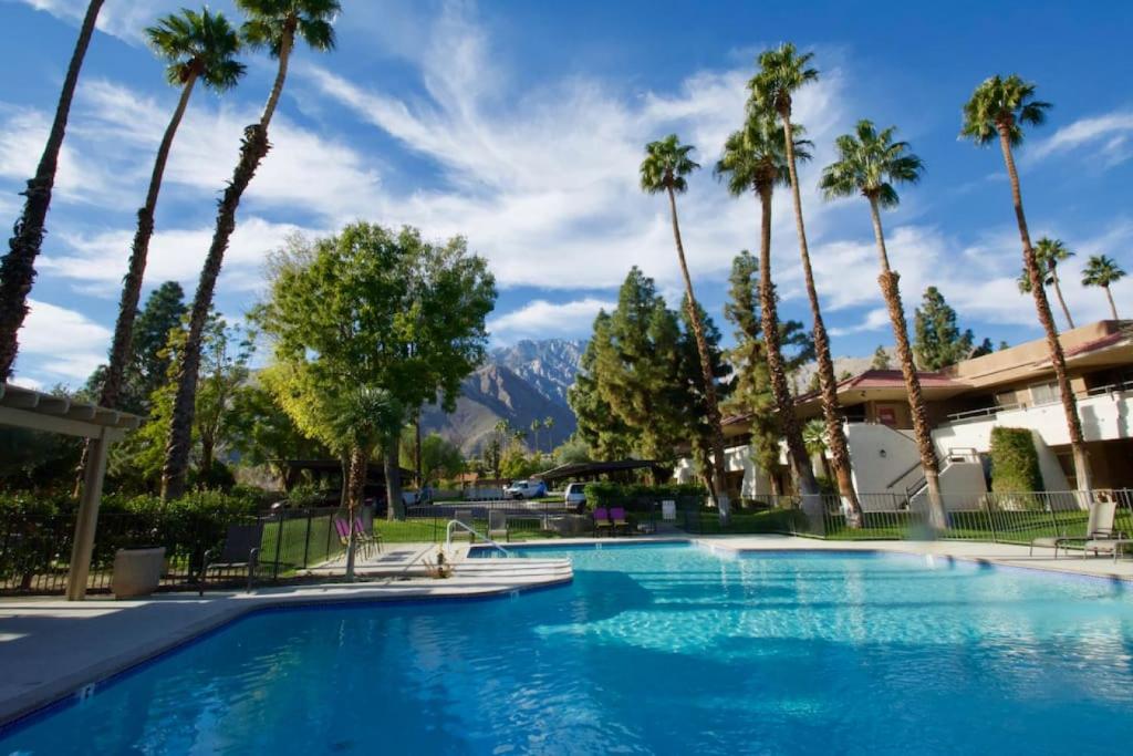 a swimming pool with palm trees and mountains at Poolside Palm Springs Getaway in Palm Springs