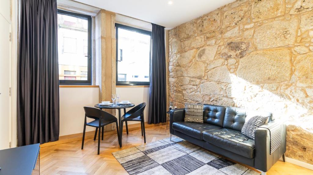 een woonkamer met een leren bank en een tafel bij Premium Duplex in Bonfim by LovelyStay in Porto