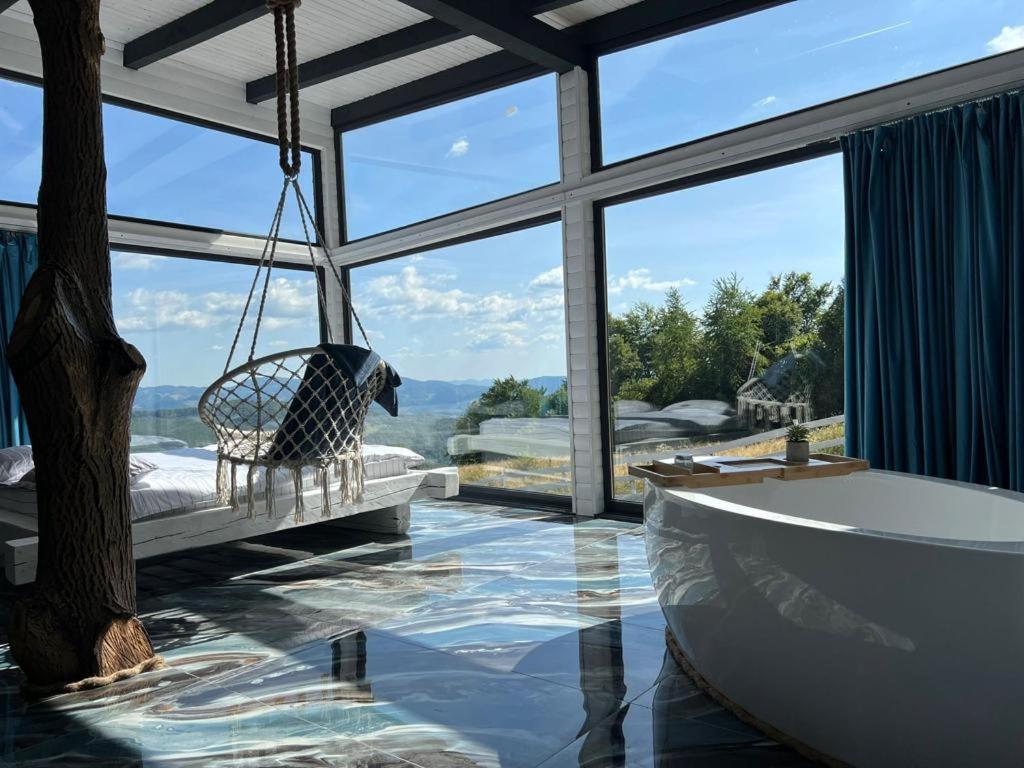 a bathroom with a bath tub and a swing at Cabana Exclusivista Wild Spa Apuseni in Buceş-Vulcan