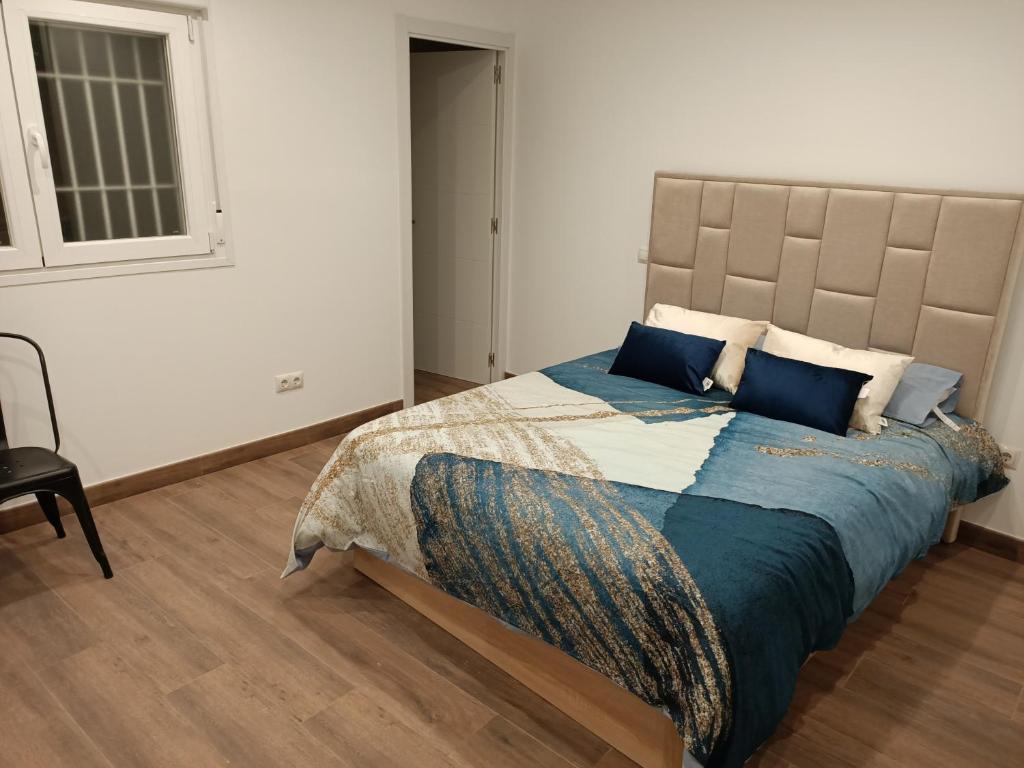 a bedroom with a large bed with blue pillows at Casa pepe in Madrid