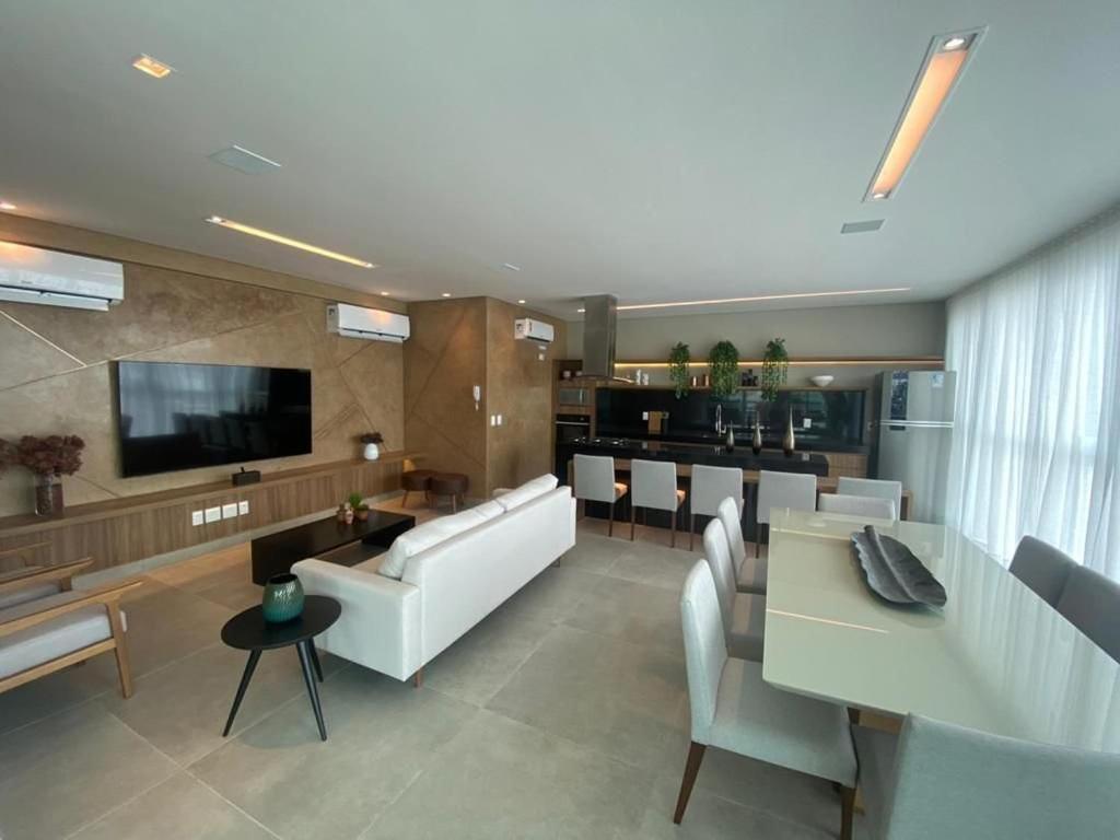 a living room with a couch and a table and chairs at Edifício Promenade II Apt 1108 -Mandi Hospitalidade in Maceió