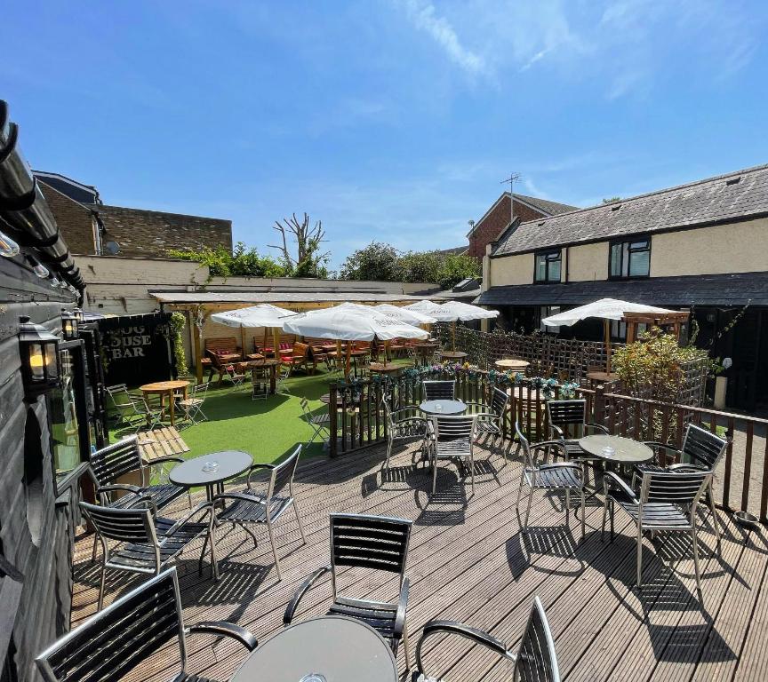 an outdoor patio with tables and chairs and umbrellas at The Windsor Trooper Pub & Inn in Windsor