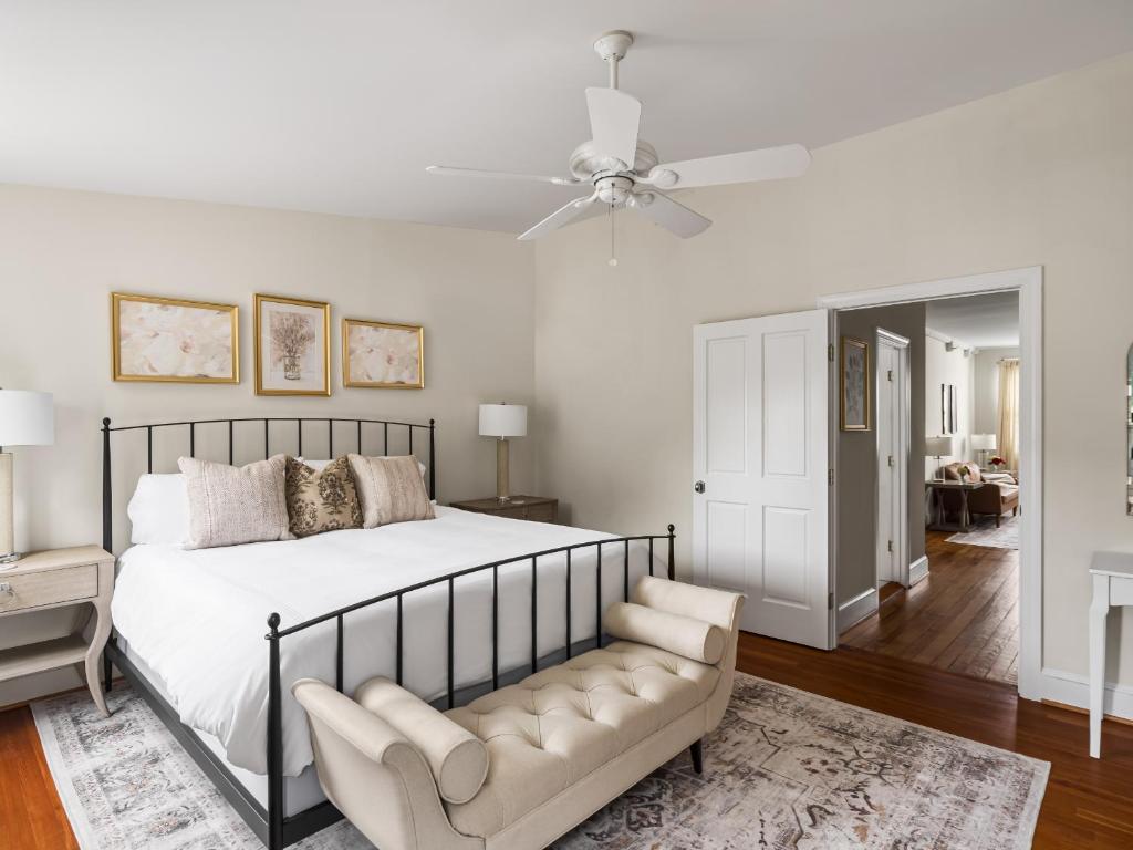 a bedroom with a bed and a couch and a ceiling fan at Flag House Inn in Annapolis