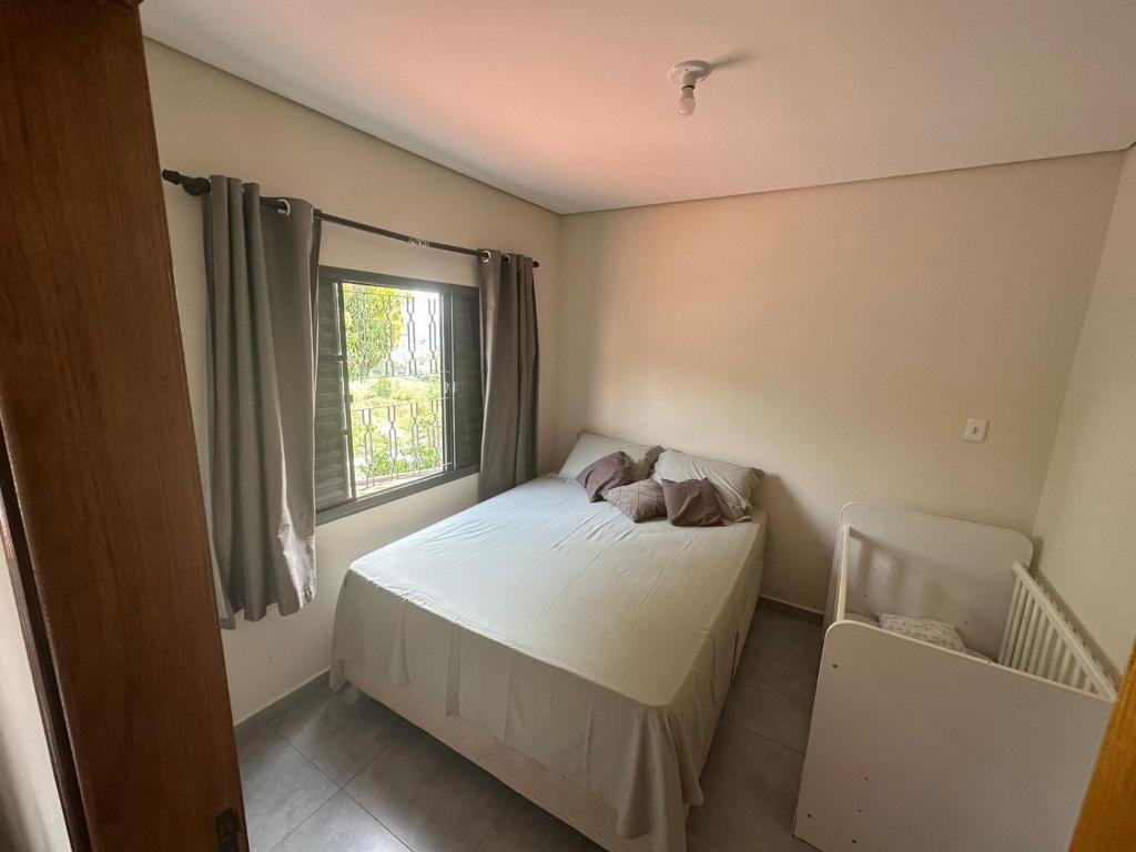a small bedroom with a bed and a window at Hospedagem Caconde Ar condicionado - Wi-fi - Garagem in Caconde