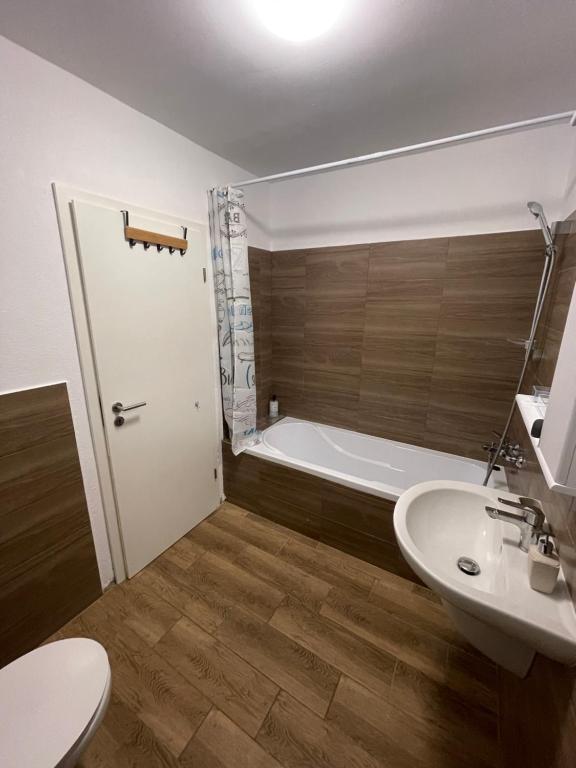 een badkamer met een toilet, een wastafel en een bad bij Boutique Apartments 2 in Sînpetru