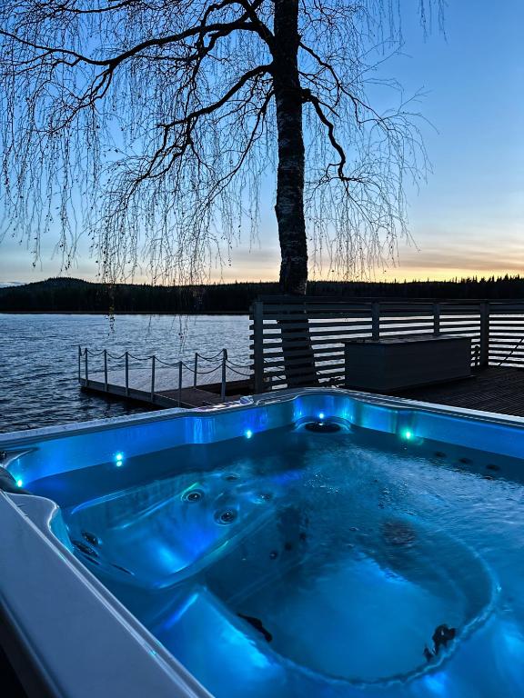 a jacuzzi tub sitting next to a body of water at Luxurious Villa Kinos with Jacuzzi in Rovaniemi