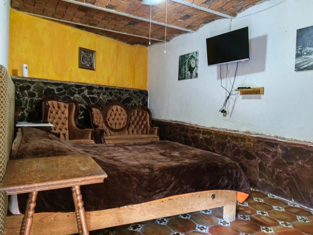 LA CASA DE LOS MANGOS AJIJIC في San Antonio: غرفة بسرير وتلفزيون بشاشة مسطحة