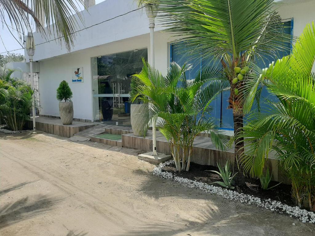 una casa con palmeras delante en Hotel Sunset Beach, en Cartagena de Indias