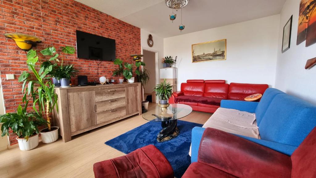 a living room with a red brick wall at 3 raum Ferienwohnung am Dresden Hauptbahnhof in Dresden