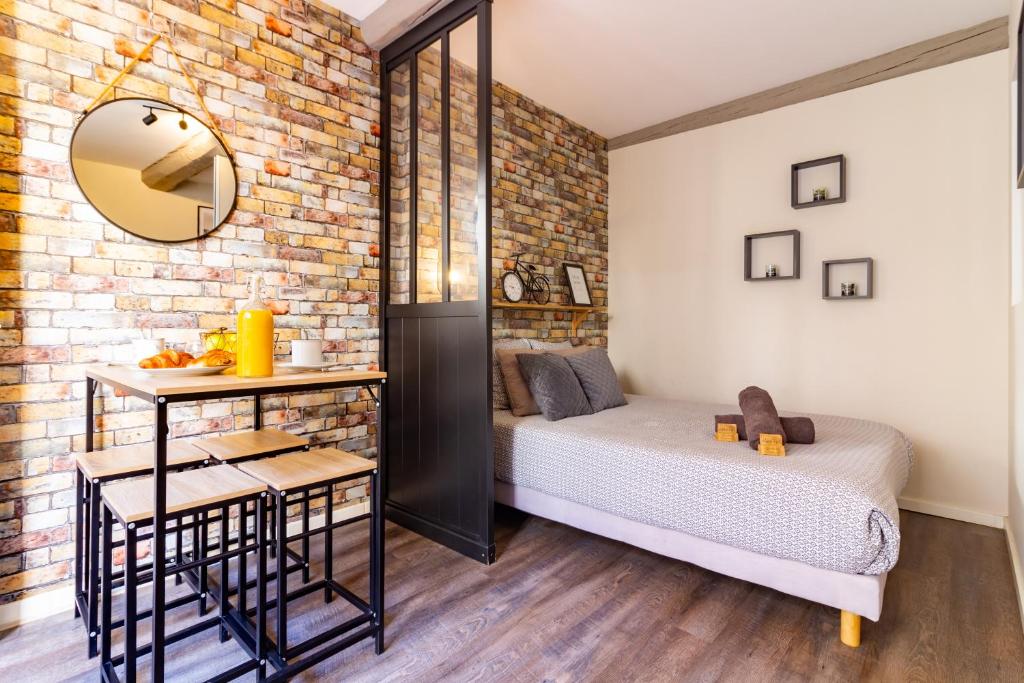 una camera da letto con un letto e un muro di mattoni di LE COSMO Du Grand Bassin Avec Terrasse a Castelnaudary