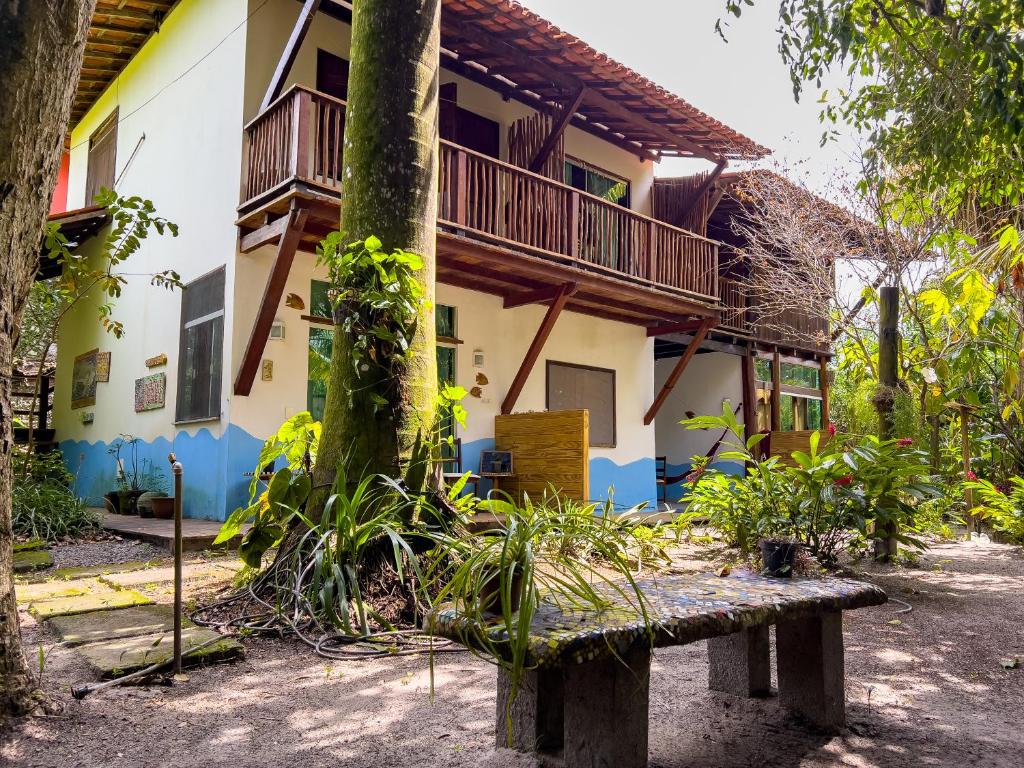 un bâtiment avec un arbre et un banc devant lui dans l'établissement Barra Quintal Apto 04, à Barra Grande