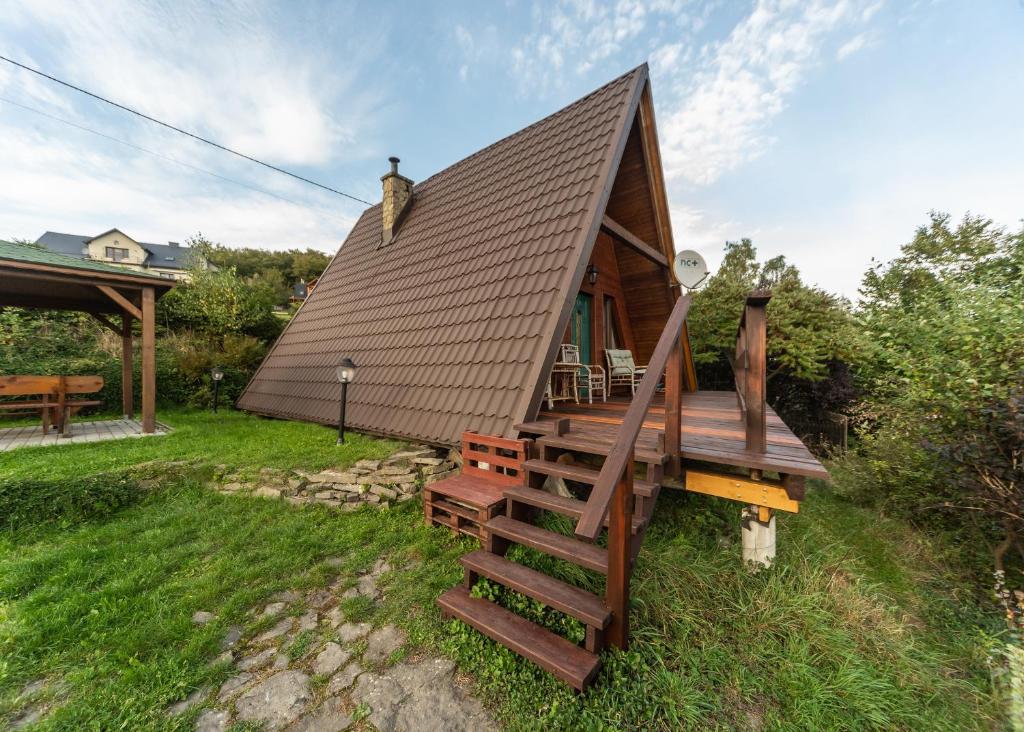 une petite cabine avec une terrasse et un toit dans l'établissement Domek Widok, à Międzybrodzie Bialskie